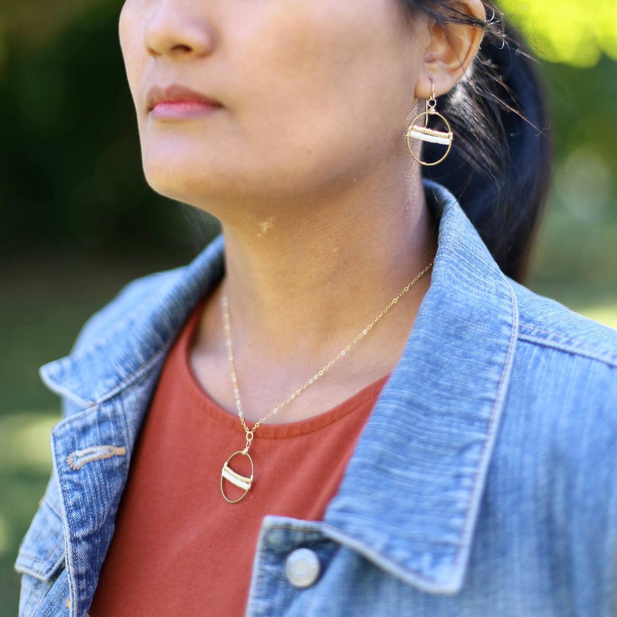 Inspired by the seeds of hope brought by our newest artisans from Afghanistan, this necklace will remind you of the hope available for all of us. Encircled by a hoop of gold-fill wire, cream and white seeds are held in perfect tension. Refugee made gifts. Fashion for good.