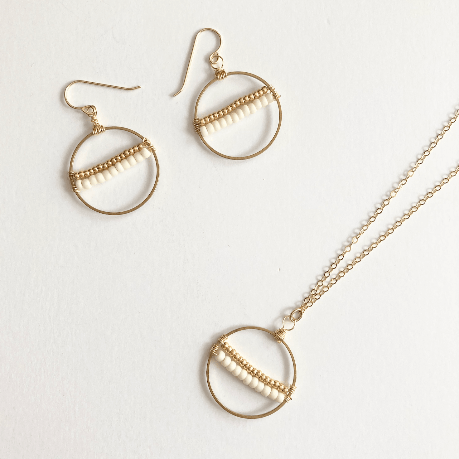 Inspired by the seeds of hope brought by our newest artisans from Afghanistan, this necklace will remind you of the hope available for all of us. Encircled by a hoop of gold-fill wire, cream and white seeds are held in perfect tension. Refugee made gifts. Fashion for good.